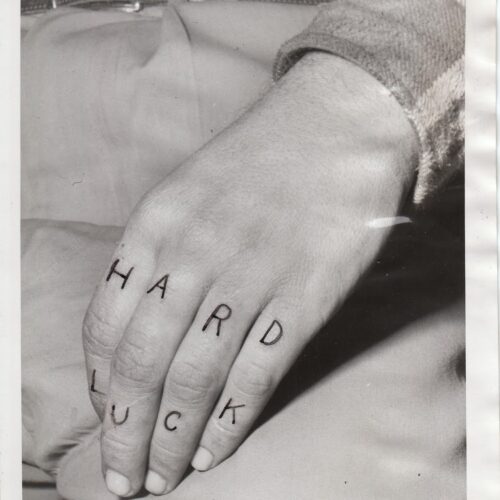 Billy Cook's hand with letters on fingers spelling "HARD LUCK"